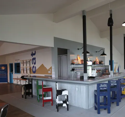 Bar counter with colourful stools inside The Cape restaurant