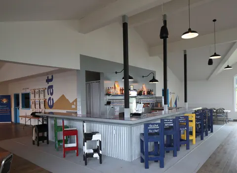 Bright interior of The Cape restaurant with bar stools and mountain views