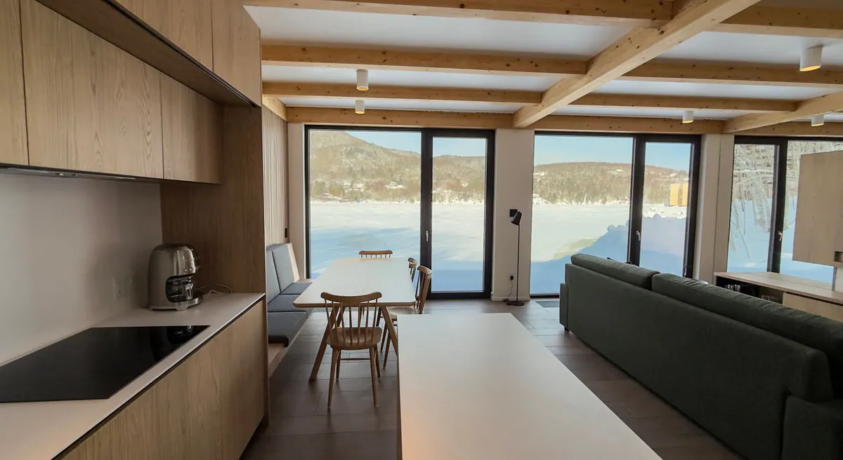 Open-plan living room with oak joinery and floor-to-ceiling windows onto the frozen bay