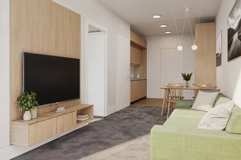 Living room with oak joinery, a wall-mounted TV and a green sofa