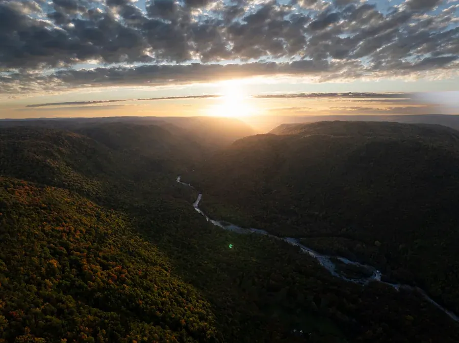 Sunrise over a forested river valley in the Cape Breton Highlands
