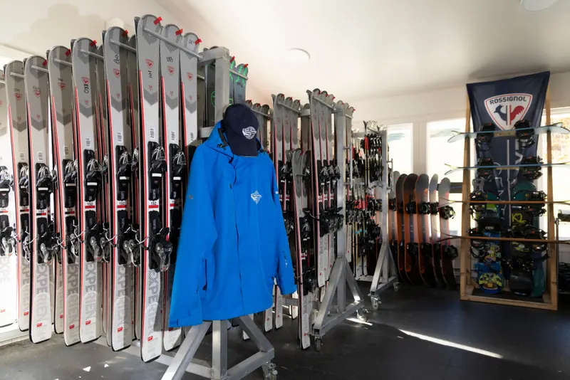 Rental shop with skis in racks and a blue Cape Smokey jacket