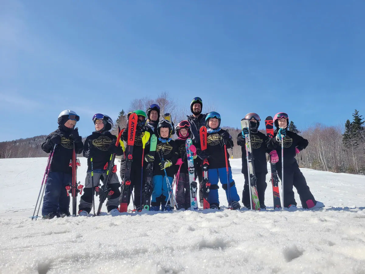 Group of young skiers with their instructor standing in the snow