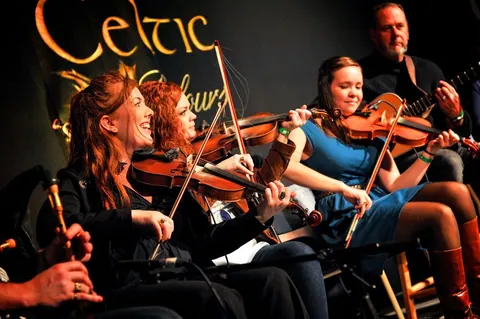 Fiddlers performing on stage at a concert