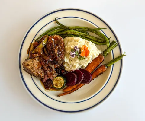 Plated dish with roasted vegetables and green beans