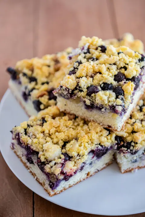 Squares of blueberry crumble bar on a white plate