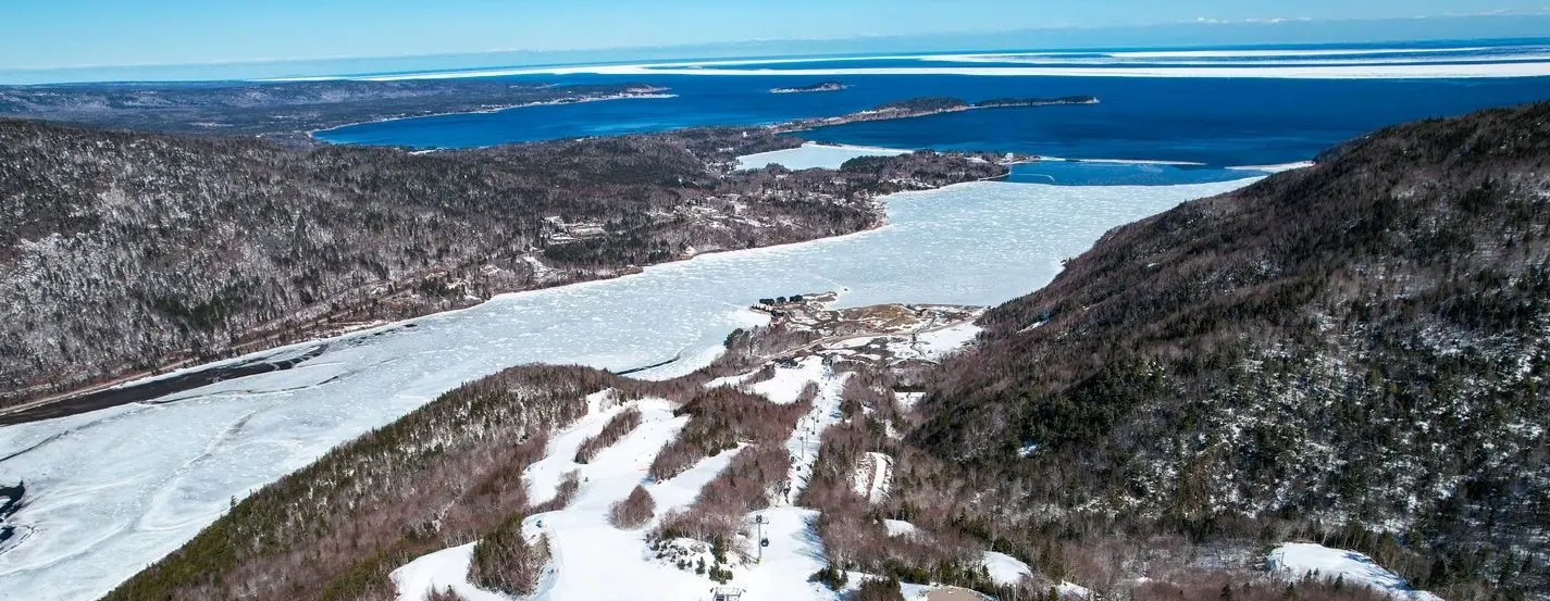 Aerial view of the Cape Smokey ski runs in winter above the frozen bay