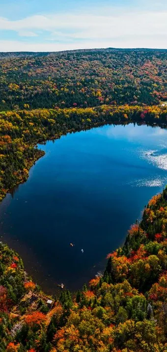 Aerial view of Hawley Lake surrounded by autumn forest