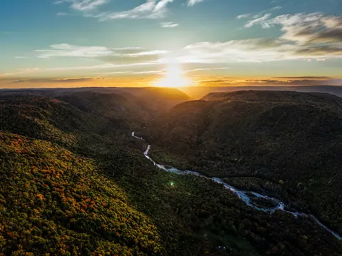 Sunset over a forested river valley in the Cape Breton Highlands