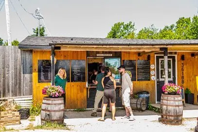 Wooden coffee kiosk of Bitsy Bean with guests ordering outside
