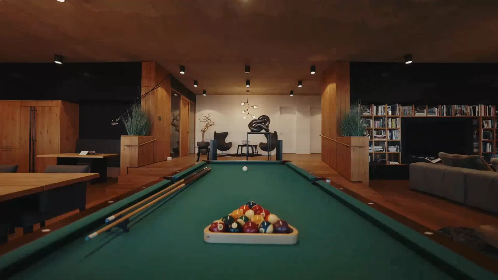 Games room at Red Head Cliffs: a green pool table with racked balls, timber walls and a library behind