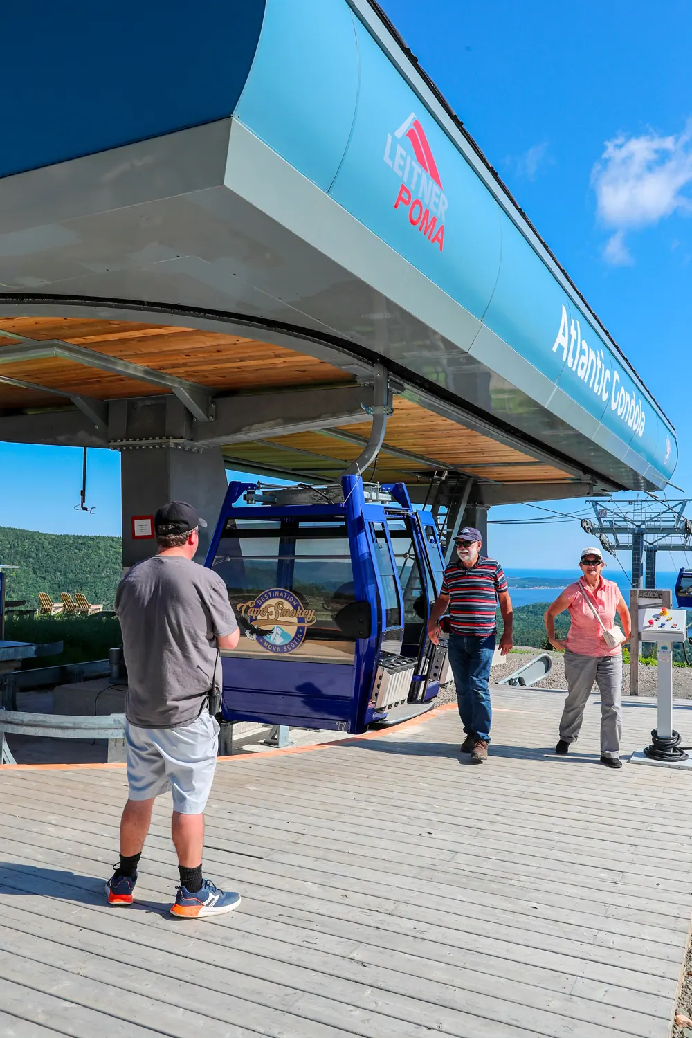 Visitors stepping out of a gondola cabin at the summit station