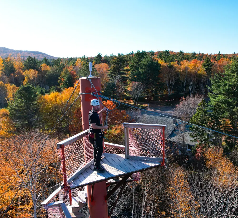 Person on a zip line platform above autumn forest