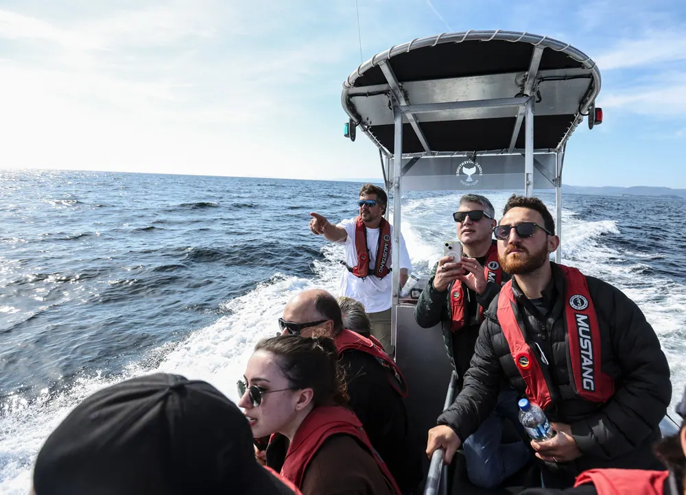 Passengers in life jackets on a fast tour boat out on the ocean
